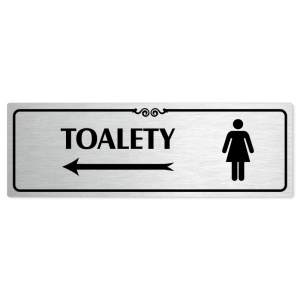 Toalety vlevo ženy, 240x79mm, stříbrná popiska s ozdobou uprostřed
